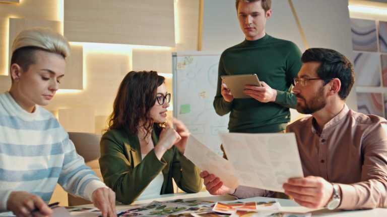 Designers reviewing printed graphic design concepts